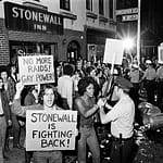 AI-generated black and white illustration depicting protesters outside the Stonewall Inn on Christopher Street in Greenwich Village, New York, during the 1969 Stonewall uprising. Crowd holds signs reading "No More Raids, Gay Power" and "Stonewall Is Fighting Back" while confronting police officers in riot gear. Note: This is an AI-generated illustration, not a historical photograph.