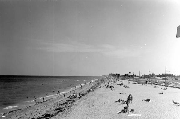 Vintage postcard photograph of Dania Beach, Florida, showing the beachfront hotel and coastline in the 1960s.